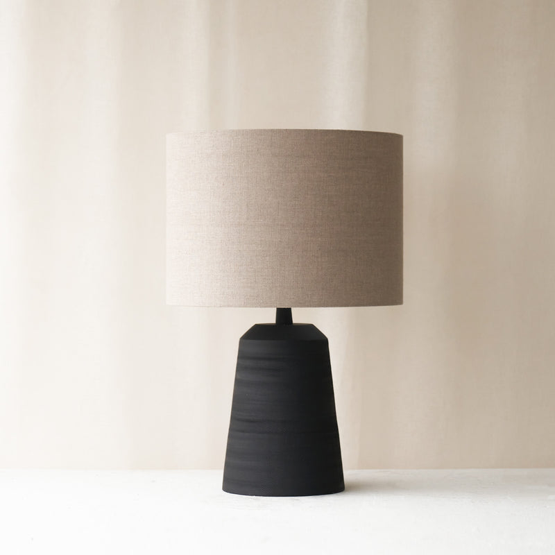 Lilou Table Lamp, black and sleek shaped. Sophisticated and stylish piece. It is a versatile piece that provides a touch of luxury and texture in any home. Available at $280.