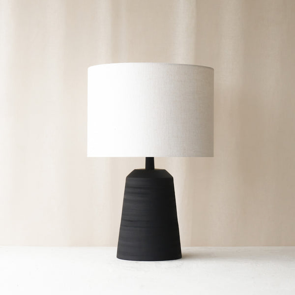 Lilou Table Lamp, black and sleek shaped. Sophisticated and stylish piece. It is a versatile piece that provides a touch of luxury and texture in any home. Available at $280.